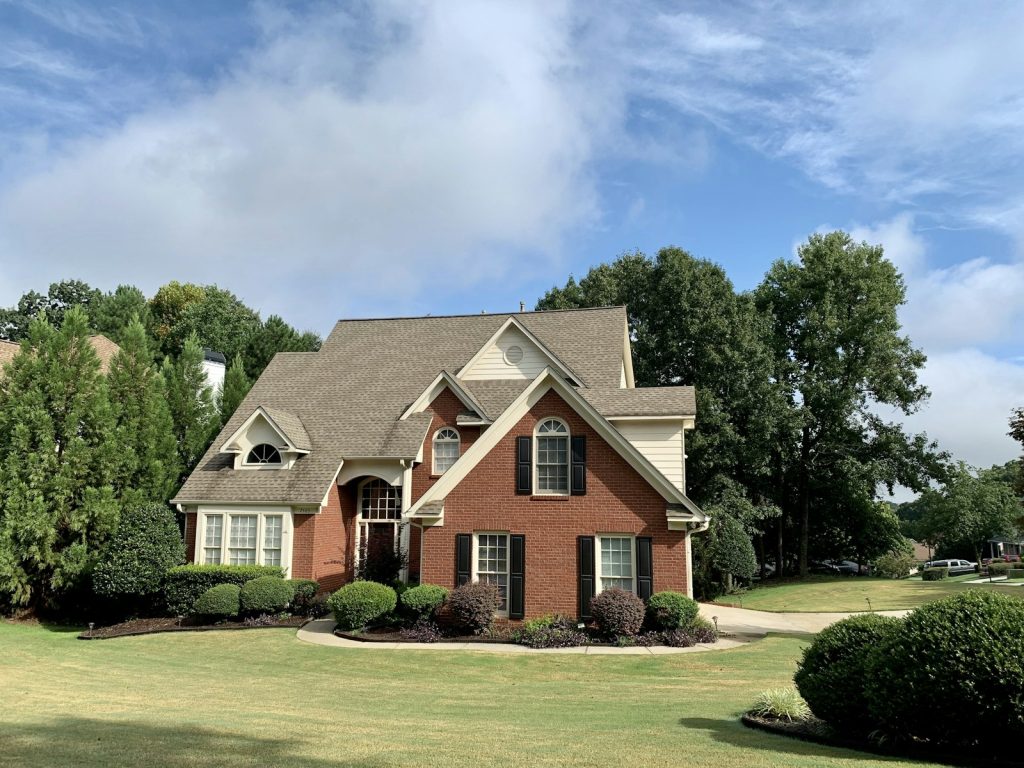 Detached brick house representing buying a property